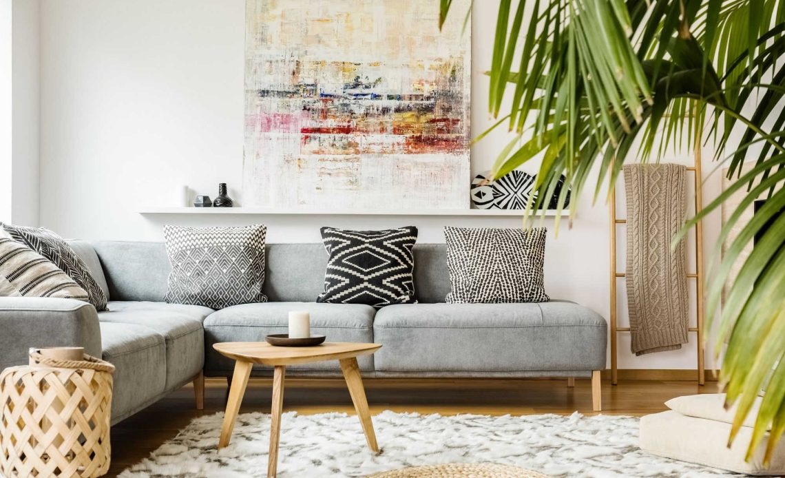 living room with grey sofa, cream rug and plants
