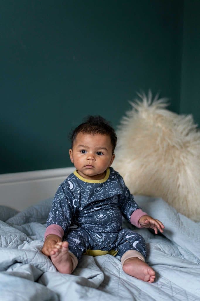Baby wearing an ethical sleepsuit from The Bright Company 