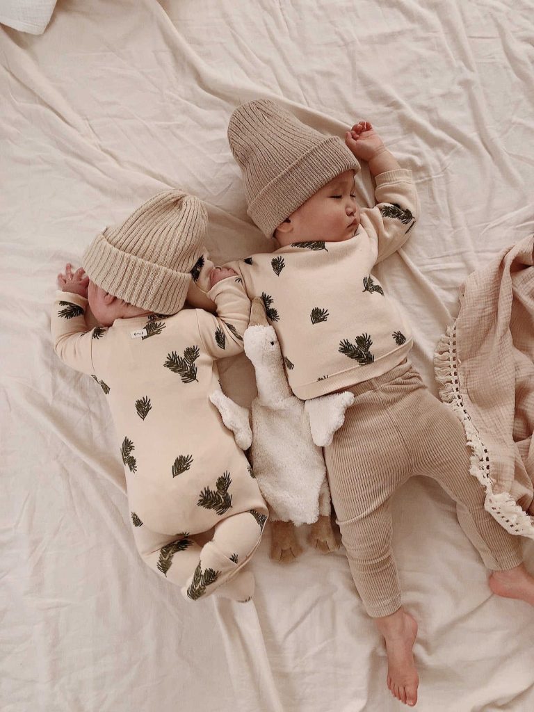 Two twin babies wearing sustainable baby clothes from Organic Zoo.