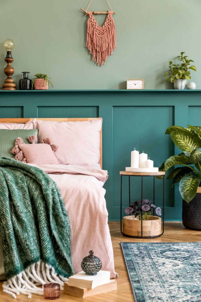 Cosy bed with pink bedding in green bedroom