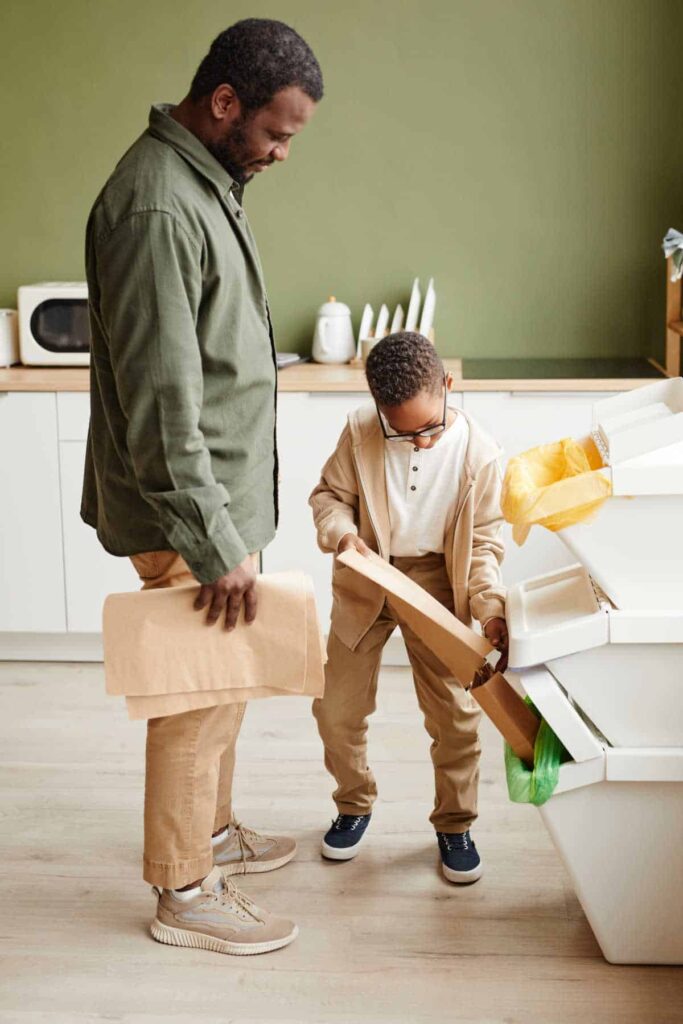 Father and son sorting items for recycling in kitchen